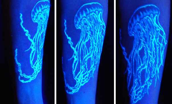 Glow in the dark tattoo of a jellyfish visible under black light on forearm.