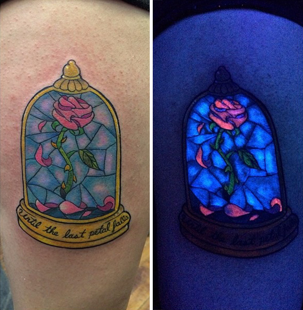 Glow in the dark tattoo of a rose under a glass dome, illuminated under black light, showcasing vibrant colors.