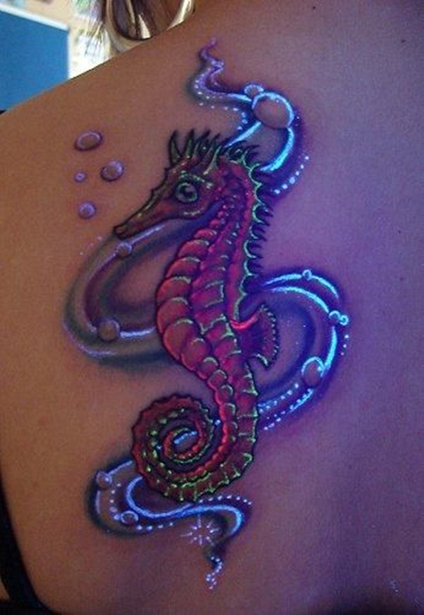 Seahorse glow in the dark tattoo on shoulder, illuminated under black light.