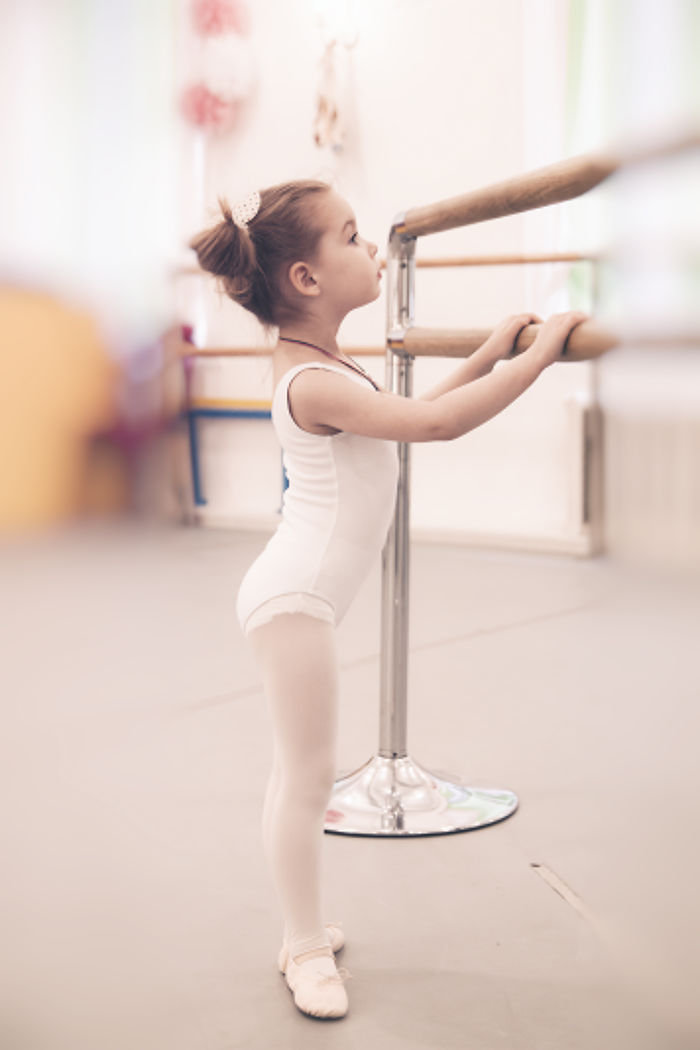 Young girl practicing ballet at barre, capturing the essence of ballet celebration.