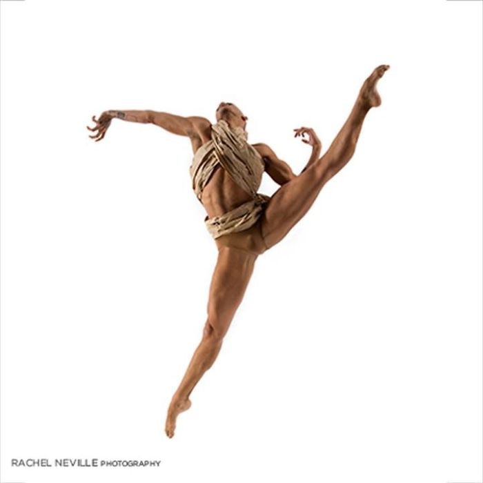 Ballet dancer performing a dynamic leap, showcasing athleticism and grace with wrapped costume.