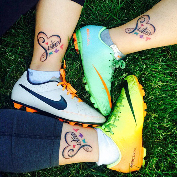 "Sister tattoos with colorful hearts on ankles in soccer cleats, symbolizing sibling bond."