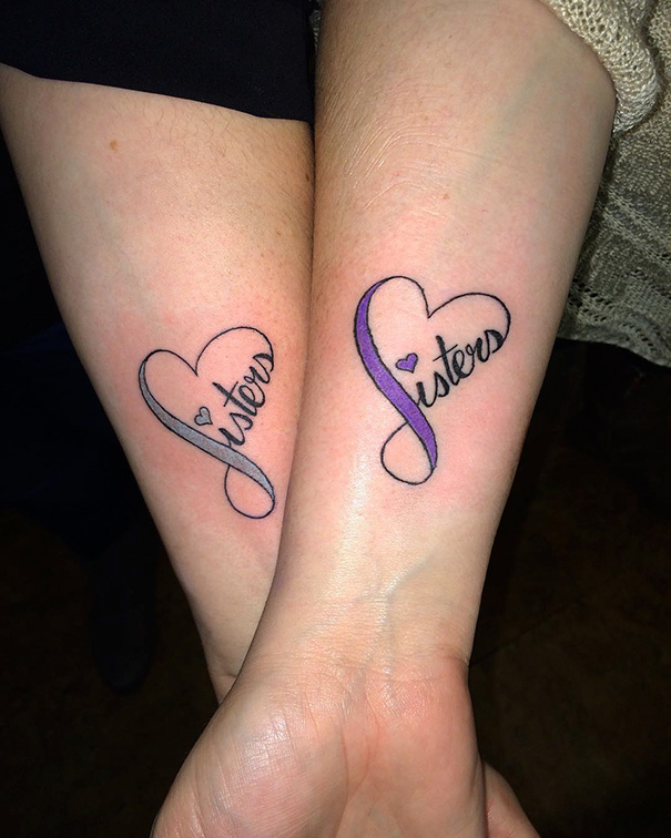 Matching "sisters" heart tattoos on forearms, symbolizing sister bond and unity.