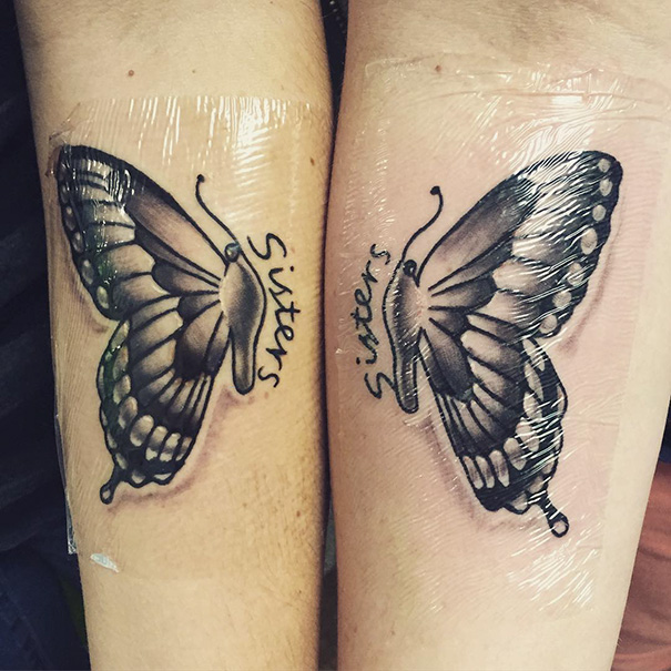 Butterfly tattoos on two arms with the word "Sisters," symbolizing sister bond.