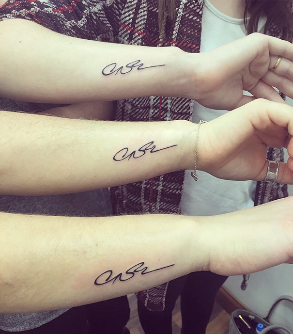 Three matching sister tattoos in cursive on forearms, symbolizing a strong sibling bond.