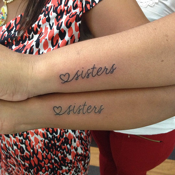 Matching sister tattoos with hearts on forearms symbolizing their bond.