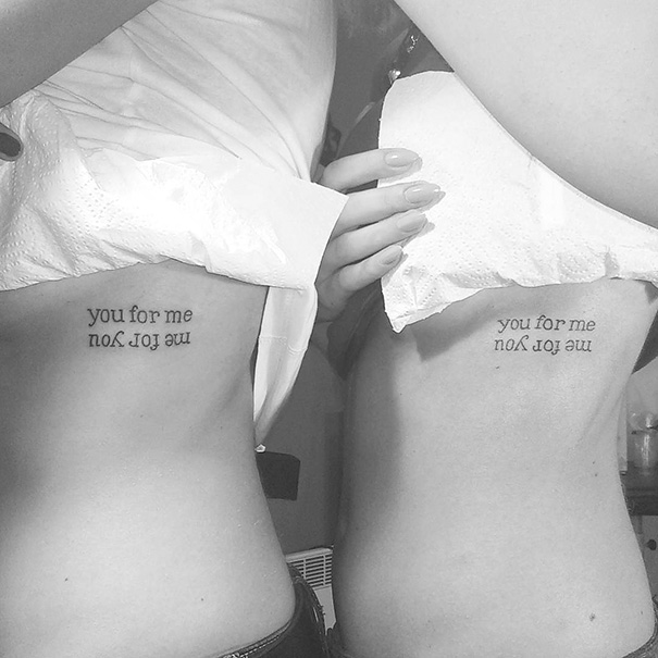 Matching sister tattoos reading "you for me, me for you" on their sides.