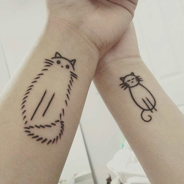 Minimalist cat tattoos on wrists symbolize sister bond.
