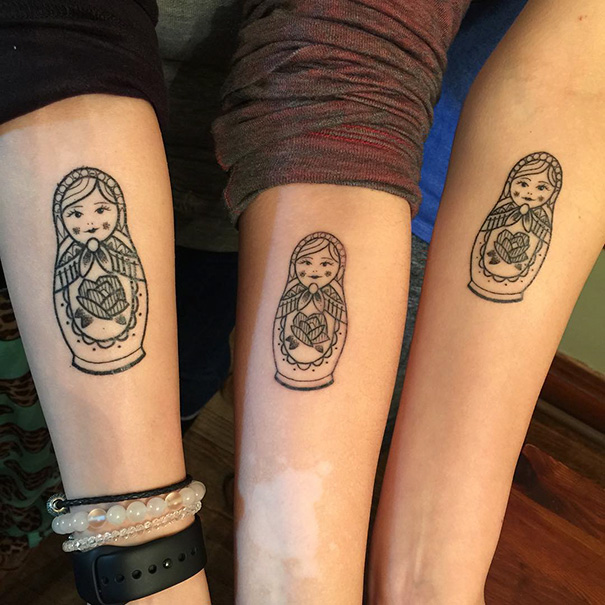 Three arms with matching sister tattoos of Matryoshka dolls, symbolizing a strong bond.