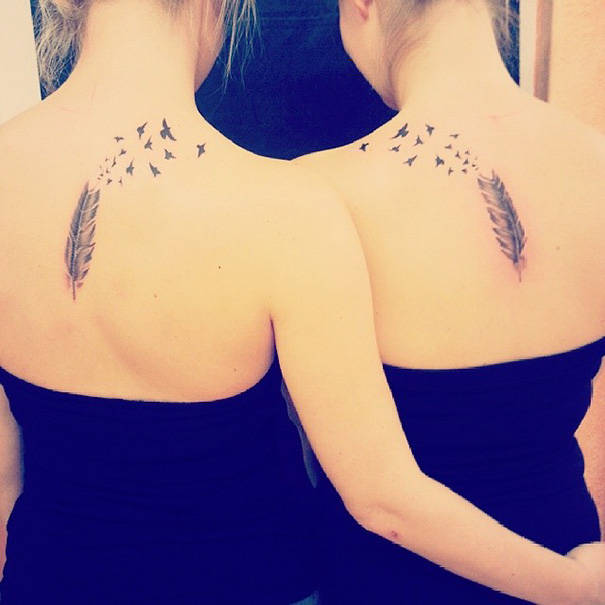 Two women with matching feather tattoos on their backs, symbolizing a sister bond.