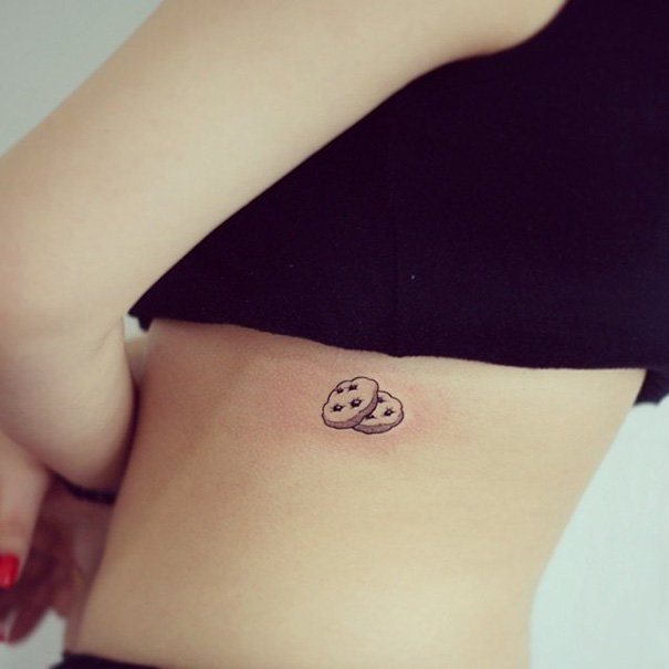 Minimalist tattoo of two button cookies on a person's side, showcasing elegant and simple ink design inspiration.