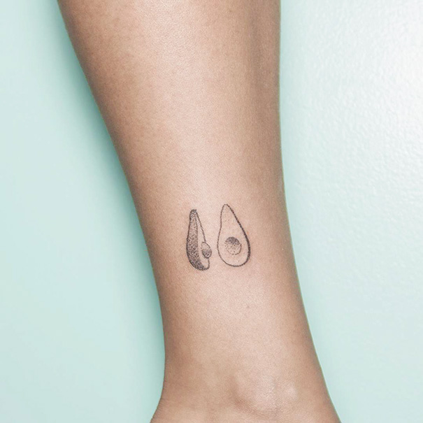 Minimalist tattoo of two avocado halves on an ankle.