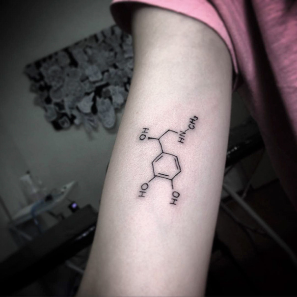 Minimalist molecule tattoo on an arm, showcasing simple and elegant ink design.