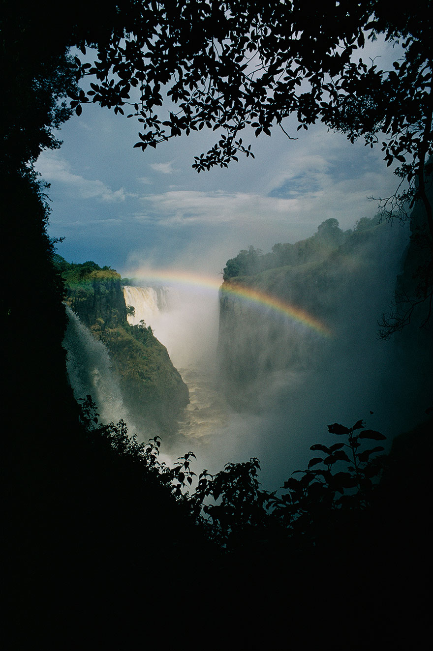 A Rainbow Arches Over Victoria Falls In Zimbabwe