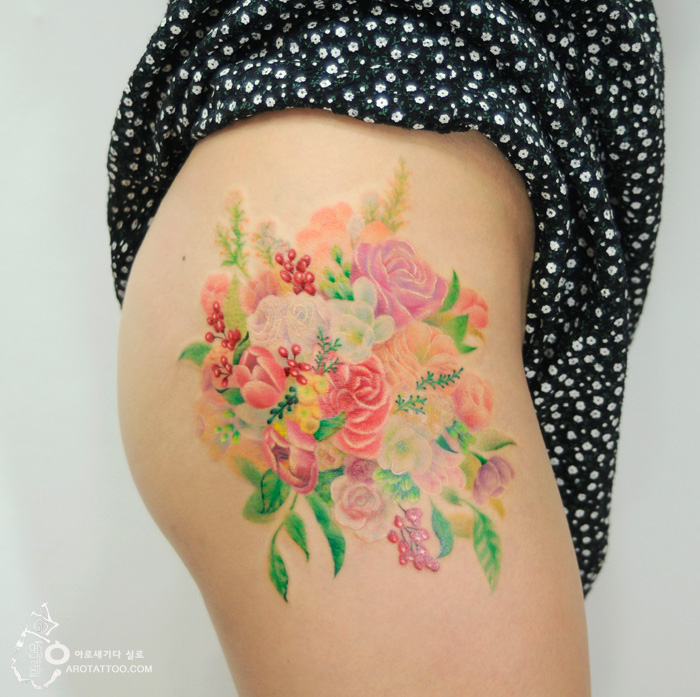 Watercolor-inspired flower tattoo on skin, featuring vibrant roses and greenery. Watercolor-inspired flower tattoo on skin, featuring vibrant roses and greenery.