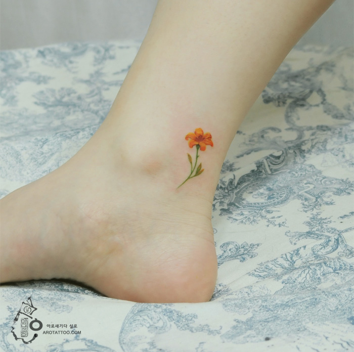 Delicate flower tattoo on ankle mimics watercolor painting style on skin. Delicate flower tattoo on ankle mimics watercolor painting style on skin.