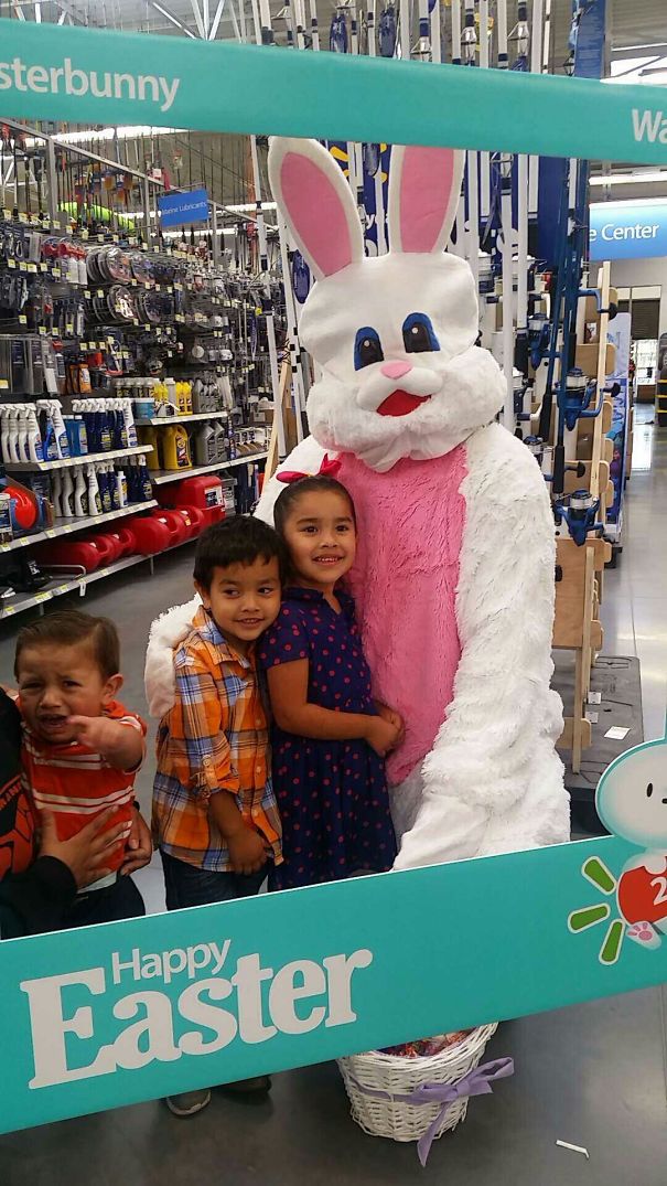 Children posing with a large, vintage Easter Bunny costume in a store setting.