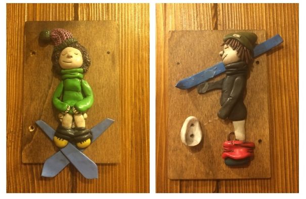 Funny bathroom signs with clay figures on wooden plaques.