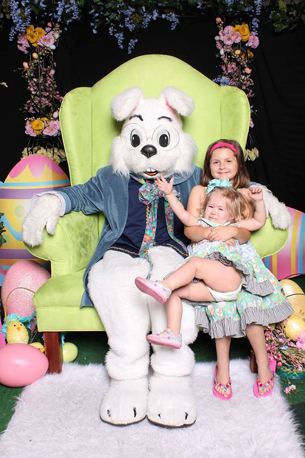 Vintage Easter Bunny with children on a large green chair surrounded by colorful eggs and flowers.