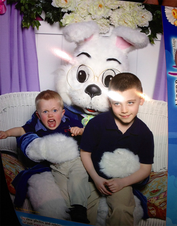 Two children sitting with a giant vintage Easter bunny costume, one child appears uneasy.