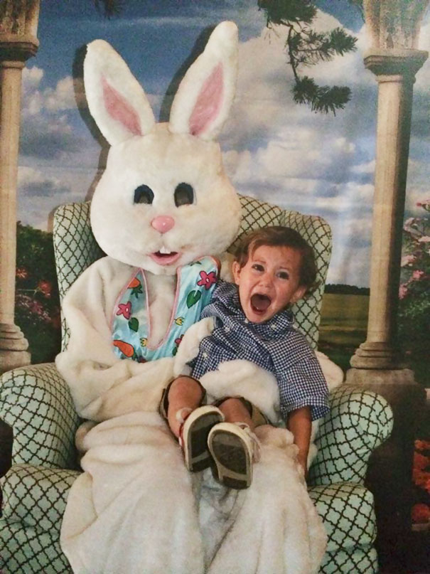 A vintage Easter Bunny costume with a child looking startled on its lap.