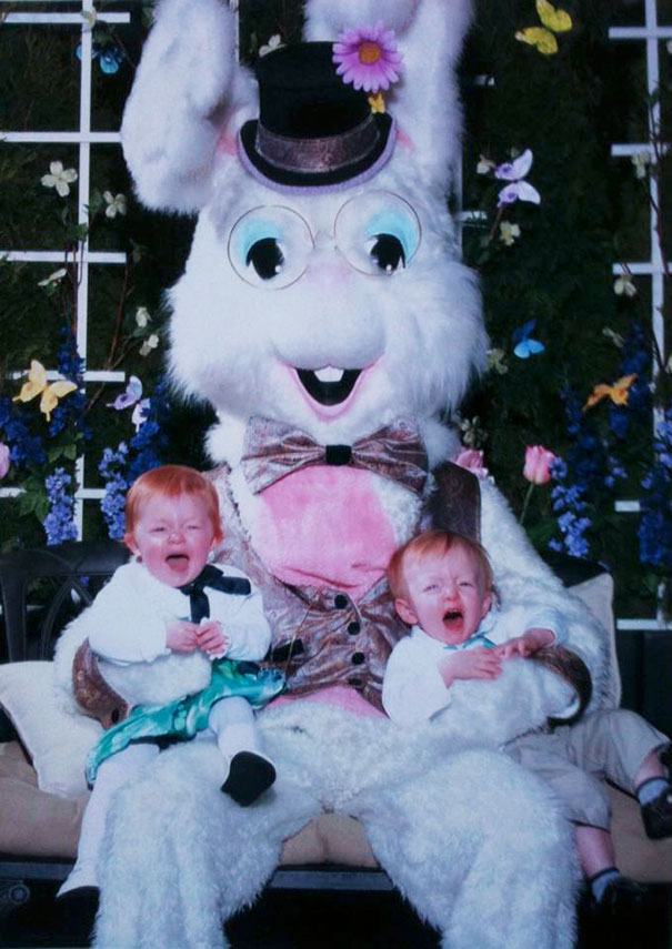 Two children crying on the lap of a vintage Easter Bunny with a whimsical hat and bow tie.