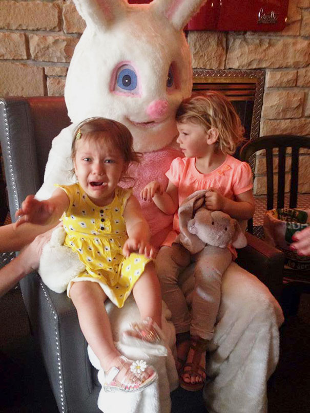 Two young children sitting with a vintage Easter Bunny, one looking scared while the other holds a stuffed toy.