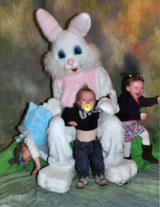 Three children appearing frightened sit with a vintage Easter bunny costume.