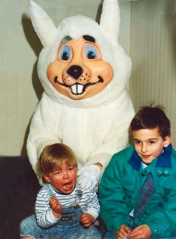Vintage Easter bunny with two kids, one crying, and one smiling awkwardly, capturing a nostalgic yet eerie moment.