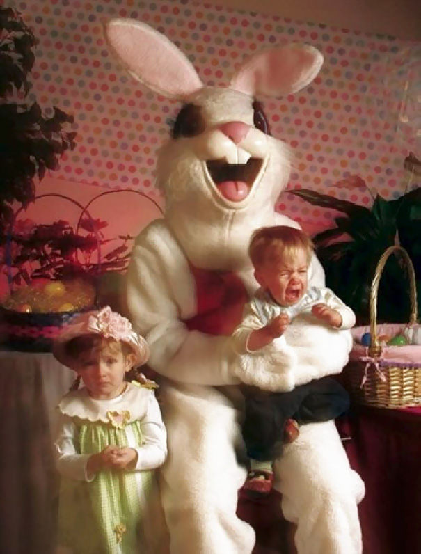 Creepy vintage Easter Bunny with two distressed children on its lap, surrounded by Easter decorations.