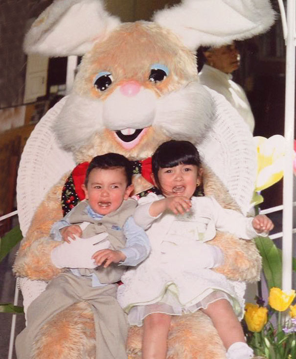 Children sitting with a vintage Easter Bunny, looking uneasy.
