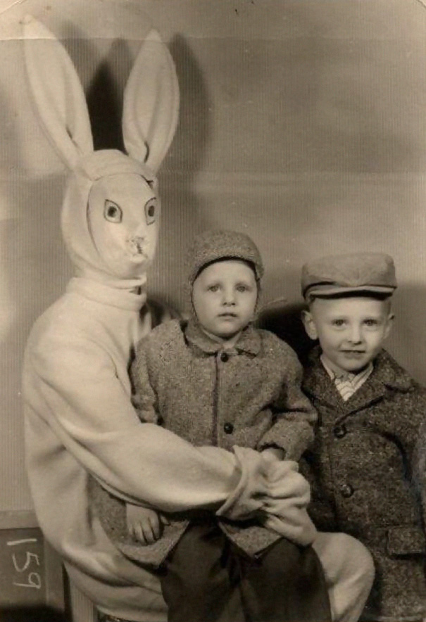 Vintage Easter bunny with two children in a sepia-toned photo, showcasing an eerie costume.