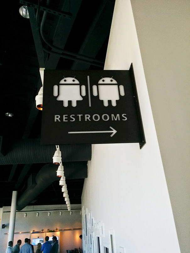 Funny bathroom sign featuring Android robot icons for restrooms.