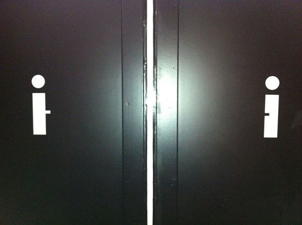 Two humorous bathroom signs with minimalist icons on black doors.