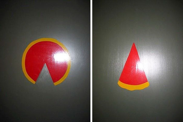 Funny bathroom signs with abstract red and yellow shapes on gray doors.
