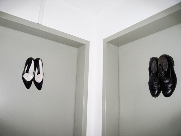 Funny bathroom signs featuring shoes on doors as gender indicators.