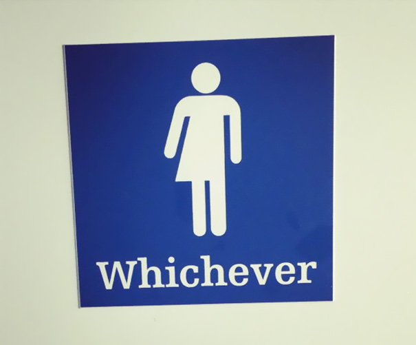 A humorous bathroom sign with a mixed-gender icon and the word "Whichever."