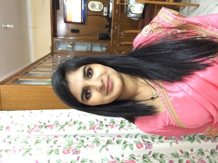 Woman in a pink traditional outfit posing indoors, illustrating a copy-paste version theme for kids and parents resemblance.