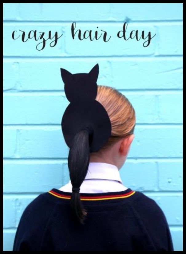 Child with a creative cat-shaped hairstyle against a blue wall for Crazy Hair Day.