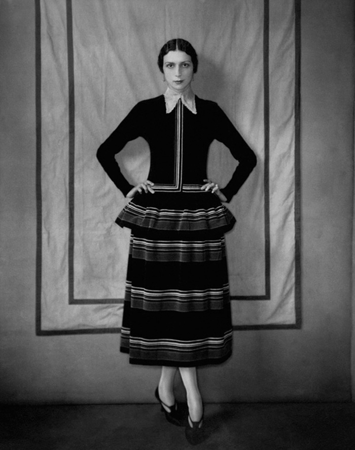 Dinarzade In A Black, Peplumed-Bodice, Velvet Dress Trimmed With Horizontal Bands Of Velvet