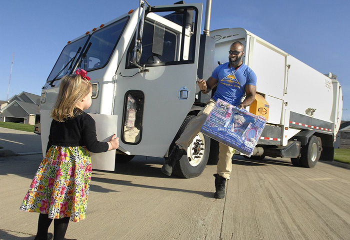 Garbage man giving a gift to a girl outside Garbage man giving a gift to a girl outside