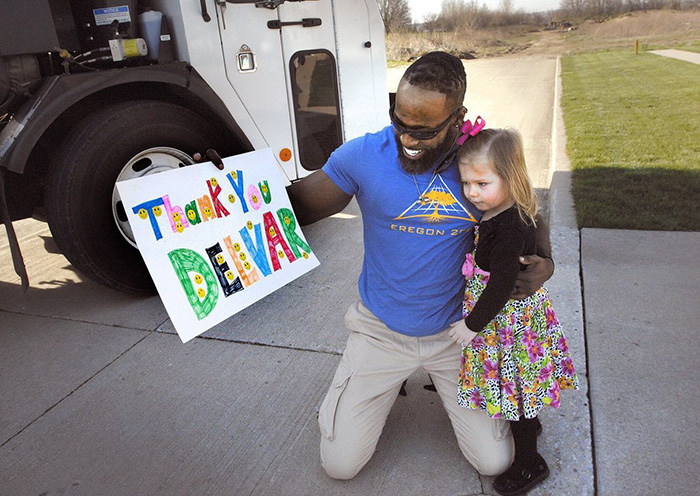 Man holding a hand made poster by a girl he is hugging Man holding a hand made poster by a girl he is hugging