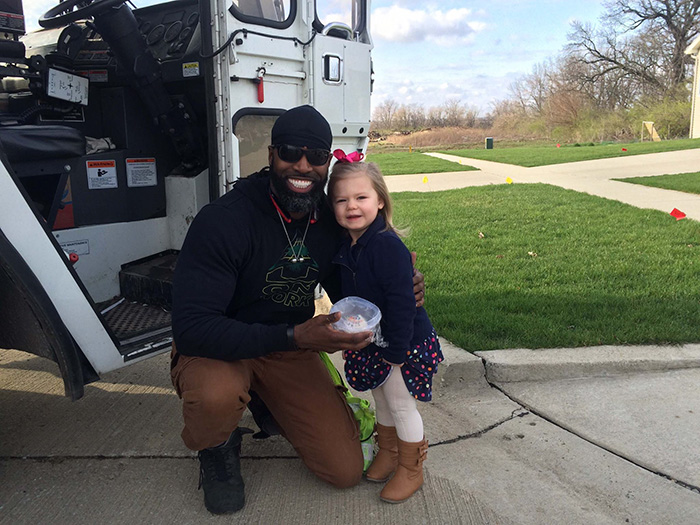 Man posing with a girl outside near a garbage truck Man posing with a girl outside near a garbage truck