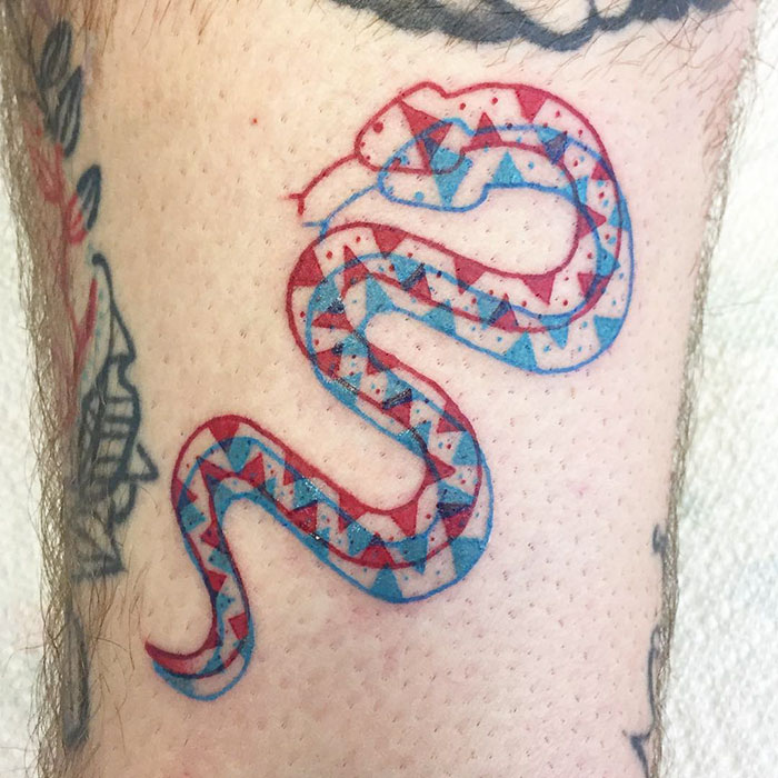 3D-inspired tattoo of a geometric patterned snake in red and blue ink on skin.