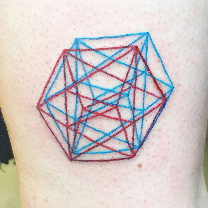 3D-inspired tattoo with geometric shapes in red and blue ink on skin.