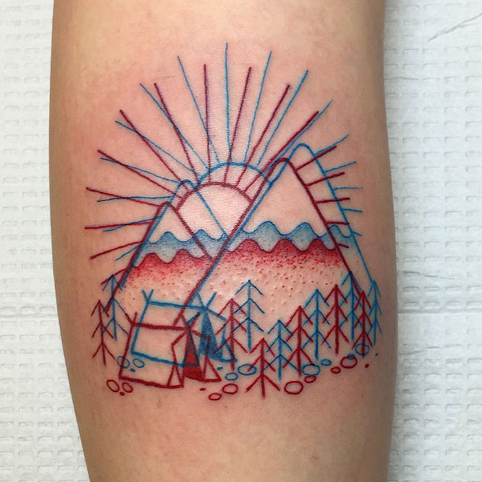 3D-inspired tattoo of geometric mountains and trees with sunrays, using blue and red lines.