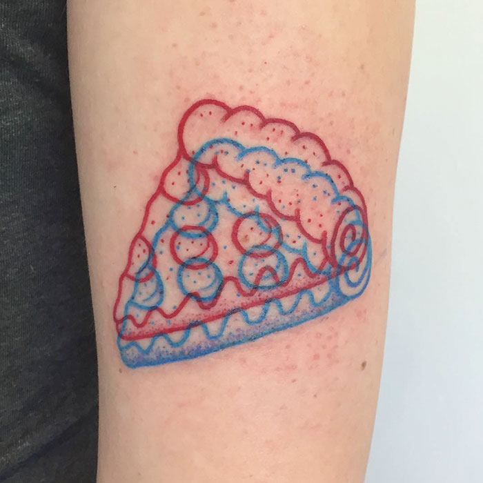 3D-inspired tattoo of a pie slice in red and blue on an arm.