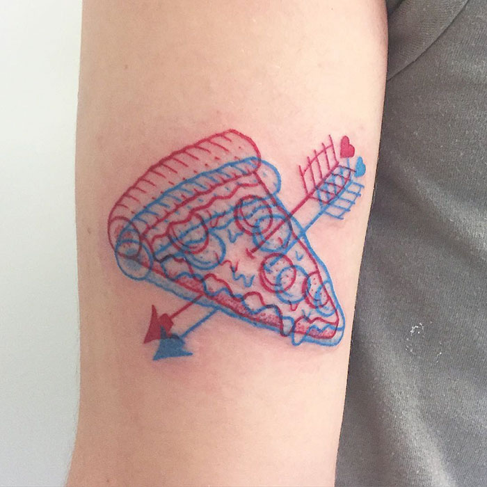 3D-inspired tattoo of a pizza slice in blue and red ink on an arm.