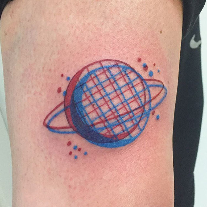 A 3D-inspired tattoo of a colorful geometric planet design on an arm.