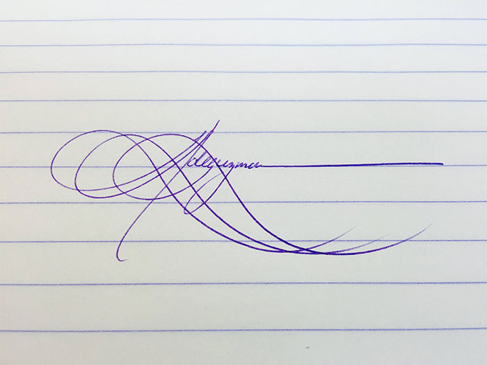 Beautiful handwriting example with elegant, intricate loops on lined paper.